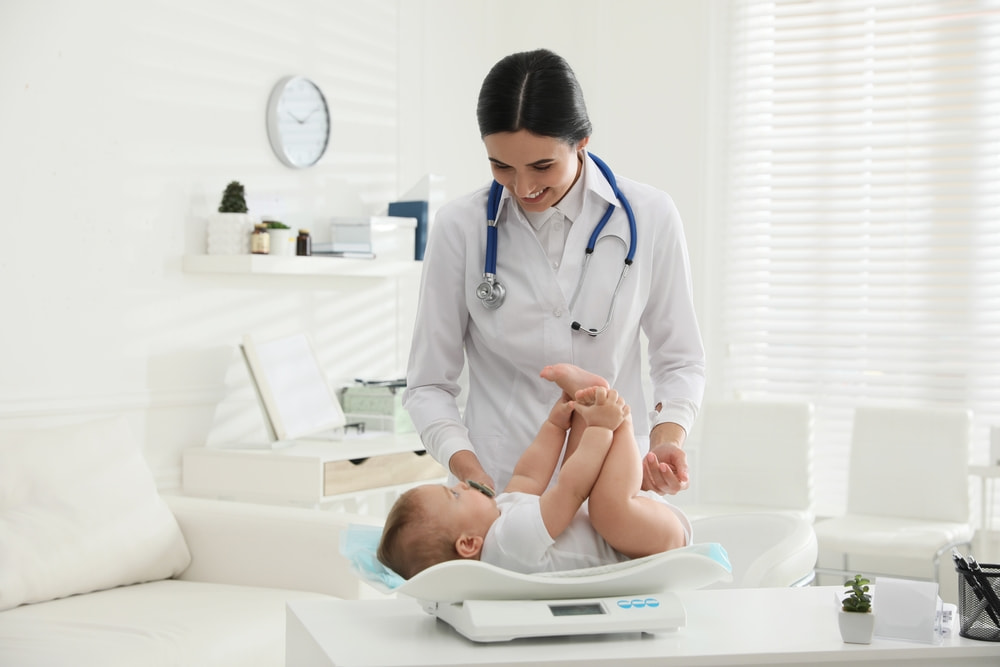 Παιδιάτρος εξετάζει μωρό στην πρώτη επίσκεψη στον παιδίατρο